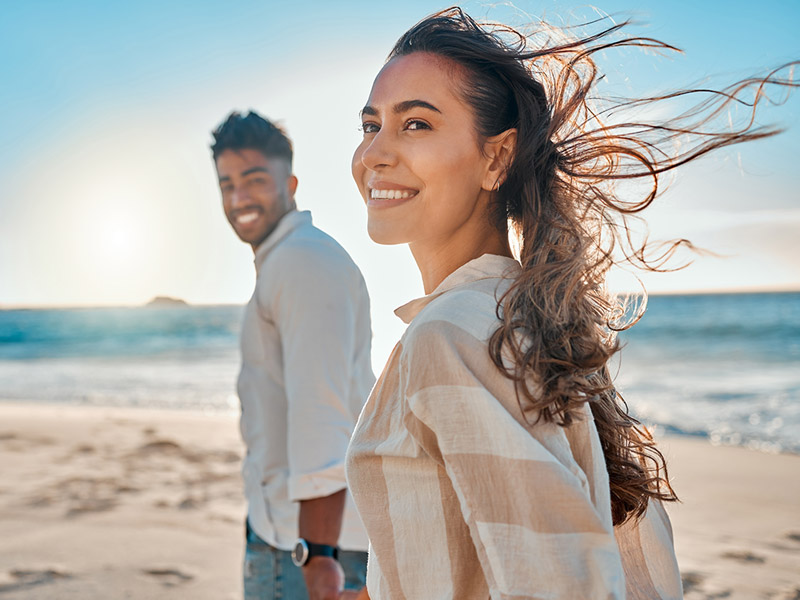couple on the beach smiling together