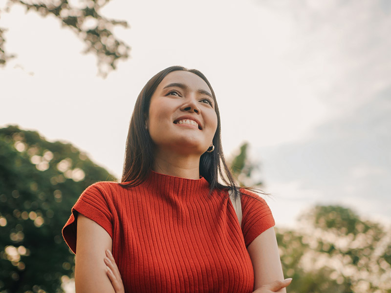 woman in red tshirt smiling while walking outside
